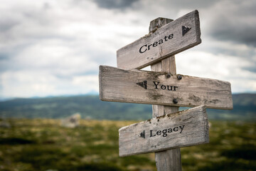 create your legacy text quote written on wooden signpost at the crossroads outdoors in nature.