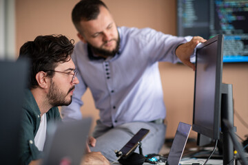 Programmers engrossed in deep collaboration, diligently working together to solve complex problems 