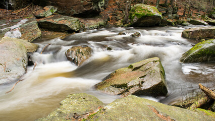 A long exposure shot of the Divok&aacute; Orlice River flowing through an autumn forest.