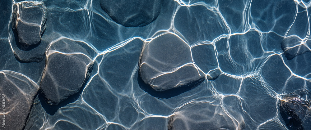 Aufkleber smooth black stones beneath clear water create mesmerizing patterns of light and shadow, evoking sen