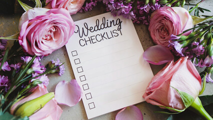 Wedding checklist surrounded by pink roses and petals.