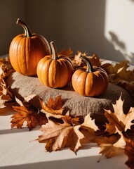 Three pumpkins arranged beside each other atop a mound of leaves Background softly blurred.