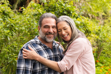 Obraz premium Happy mature couple embracing outdoors, enjoying nature and smiling together