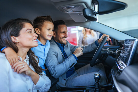 Happy Family Exploring New Car at Dealership Together