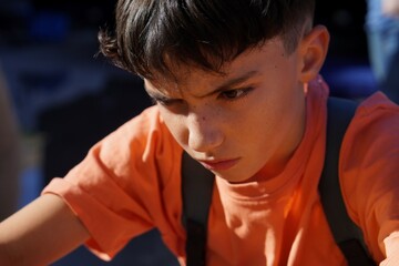 preadolescent boy with backpack, looking worried and sad as he leaves school