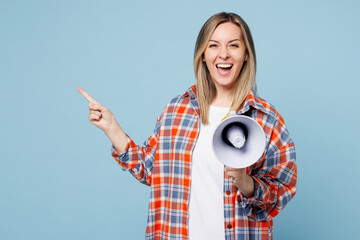 Young woman wear red shirt t-shirt casual clothes hold in hand megaphone scream announces discount sale Hurry up isolated on plain pastel light blue cyan background studio portrait. Lifestyle concept