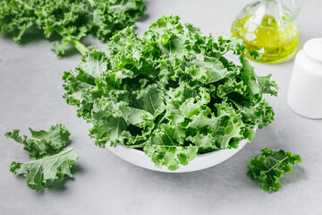 Curly Kale. Fresh raw chopped Curly Kale in bowl on gray stone background. Ready for delicious healthy salad, vegan food, superfood.