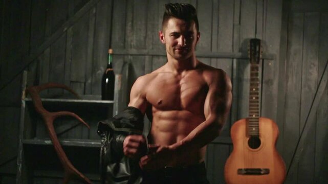 Topless guy undressed shirt. Young sexy man with muscular body takes off his shirt. Sexy male model. Seductive guy. Handsome shirtless man. Muscular male fit body. Male fashion model.