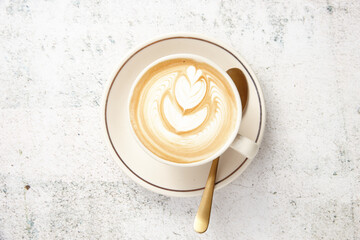 Flat white on saucer with gold spoon