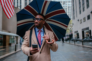 Businessman walking with union jack umbrella in new york city