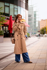 Attractive mid aged woman standing on the street and using her smarpthone