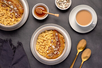 Food photography of millet porridge with caramelized banana, pecan, nuts, coconut flakes, chia, flaxseeds, honey, tea with almond milk