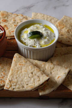 A plate of pita bread with Tzatziki dip
