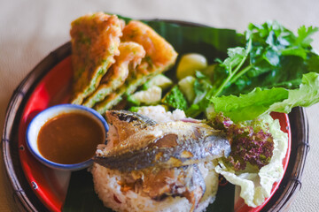 Shrimp paste sauce with crispy fried fish and sweet pork in a plate