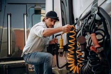 Messing with cables, installation, fix. Truck driver is near the transport outdoors
