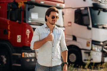 Eyewear, cool look in the sunglasses, standing. Truck driver is near the transport outdoors