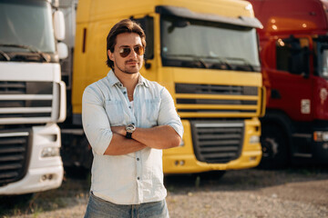Cool look, in sunglasses. Truck driver is near the transport outdoors