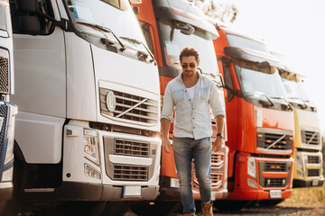 Cool look, in sunglasses. Truck driver is near the transport outdoors