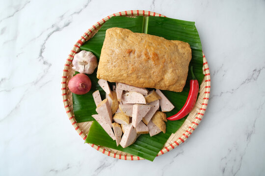 Fried Cha Lua served on a banana leaf inside a woven basket