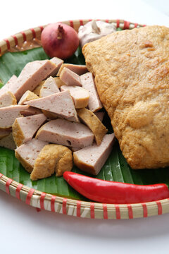 Fried Cha Lua served on a banana leaf inside a woven basket