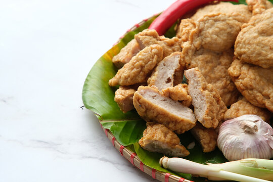 Deep fried Cha Lua slices served on a banana leaf in a woven basket.