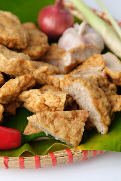 Deep fried Cha Lua slices served on a banana leaf in a woven basket.