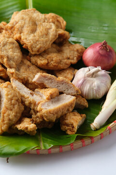 Deep fried Cha Lua slices served on a banana leaf in a woven basket.