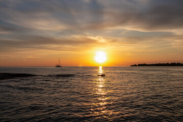 Serene coastal scene with luxury sailboat silhouetted against a fiery sky at sunset. Calm Bay of Dajla in calm Adriatic Mediterranean sea. Seen from Karigador, Istria peninsula, Croatia, Europe. Awe