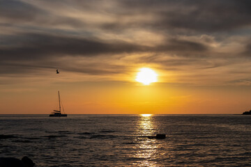 Serene coastal scene with luxury sailboat silhouetted against a fiery sky at sunset. Calm Bay of Dajla in calm Adriatic Mediterranean sea. Seen from Karigador, Istria peninsula, Croatia, Europe. Awe