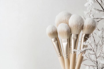 Collection of makeup brushes on a light background with decoration