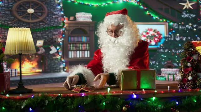 Saint Nick packs a gift box in his workshop surrounded by festive decorations. Decorating the presents with lovely ornaments for the holiday spirit, Christmas Eve journey around the world. Camera B.
