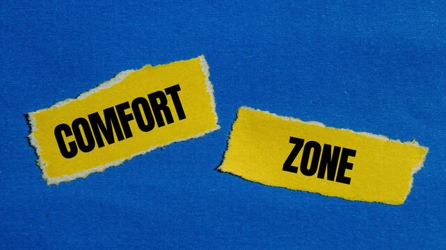 Comfort zone message writing on ripped torn yellow paper pieces on blue background. Conceptual comfort zone symbol.