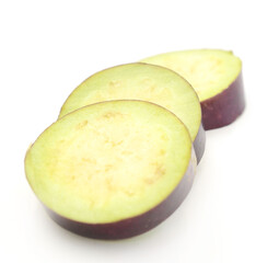 Aubergine, Solanum melongena, egg plant, single ripe fruit and halved fruit next to it - stock photo
