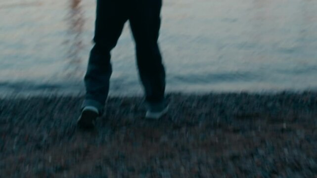 Male offender wearing black clothes and balaclava on his face running away from cops then finding hideout at waterfront after convicting serious crime