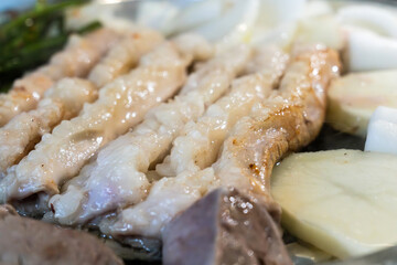 roasting pork intestines with onion, potato, chives, lung and potato on the pan