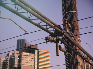 Railway overhead lines with tall building in the background.