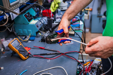 Engineers working with cables and wires on an electronic project at a workshop.