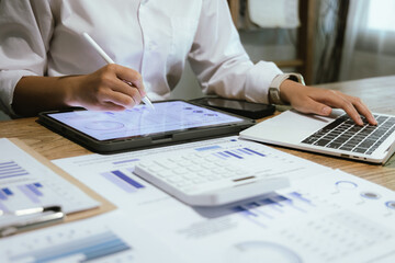 Businessman or accountant is analyzing data charts, graphs and dashboards on laptop screen to prepare statistical report.