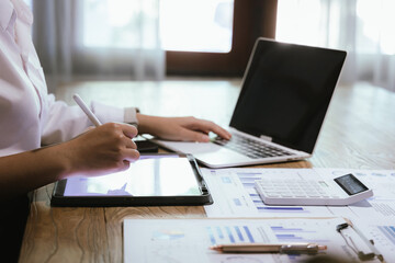 Fototapeta premium Businessman or accountant is analyzing data charts, graphs and dashboards on laptop screen to prepare statistical report.