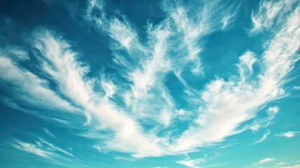 A serene sky filled with wispy clouds against a bright blue backdrop.