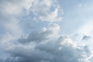 Fluffy white clouds drift across a vast expanse of blue sky