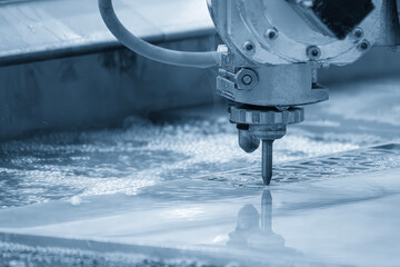 Close-up scene of multi-axis abrasive waterjet cutting machine cutting the aluminum plate.