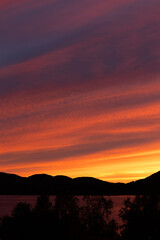Beautiful, dramatic sunset sky over the fjord in Northern Norway. Seasonal scenery of Scandinavia.