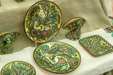 Empty crockery set. Ukrainian ceramics. Painting of plates. Clay dish utensils. Pottery bowl with birds.