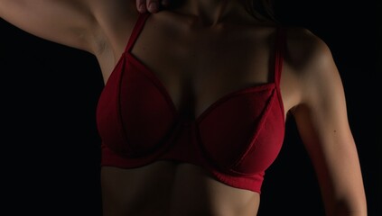 Obraz premium Portrait of a woman wearing red lingerie against a black backdrop