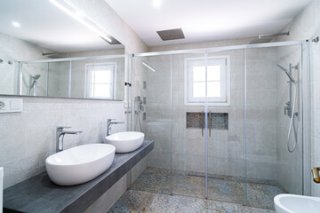 Baño con dos lavabos de diseño y ducha con cristal