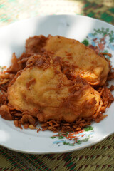 A plate of fried banana or Pisang Goreng (Musa acuminata × balbisiana), an Indonesian favorite snack. Sliced kepok bananas coated in batter and fried until crispy, offering a sweet, delightful taste.