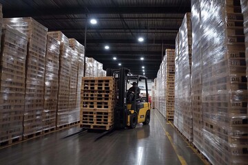 Fototapeta premium Efficient warehouse operations at dusk with a forklift maneuvering pallets. Generative AI