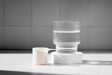 Collagen protein powder in a scoop. Glass of collagen beauty drink. Food supplement.