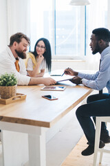Fototapeta premium Black agent and couple discussing mortgage